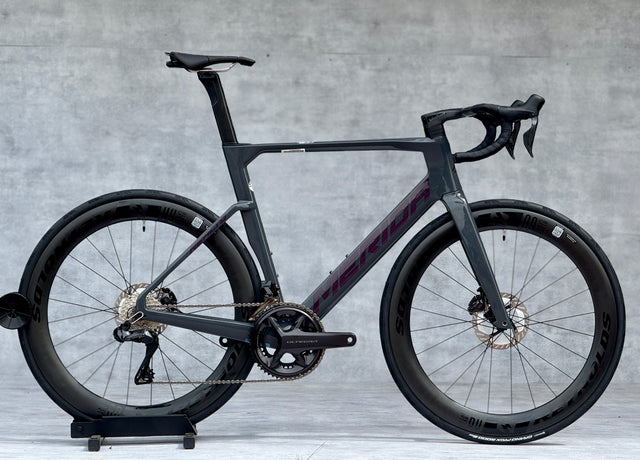Merida Reacto 9000 2025 – High-End Aero Racefiets

De Merida Reacto 9000 2025 is dé keuze voor wielrenners die maximale snelheid en efficiëntie eisen. Met een ultralicht CF5 carbon aero-frame, aerodynamische buisvormen en geïntegreerde kabelgeleiding is deze fiets gebouwd om wind te verslaan.

De fiets is afgemonteerd met de nieuwste Shimano Dura-Ace Di2 12-speed groepset, wat zorgt voor razendsnelle en nauwkeurige elektronische schakelingen. De krachtige hydraulische schijfremmen bieden maximale controle, 